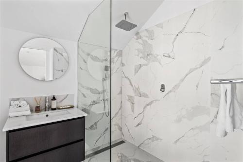 Un baño con ducha, lavabo y espejo. en Ember and Aqua - Luxury Barnhouse on the Golf Course, en Dunsborough
