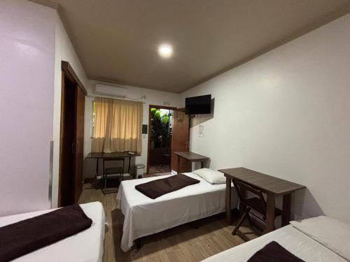 una habitación con dos camas y una mesa y un escritorio en Caminho das cataratas, en Foz do Iguaçu
