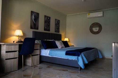a bedroom with a bed and a desk and two lamps at Casa Boutique La Corona Medellin in Envigado
