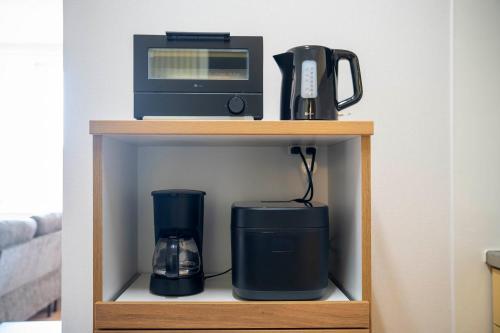 a coffee maker and a microwave on a shelf at Lambrusco in Kami-furano