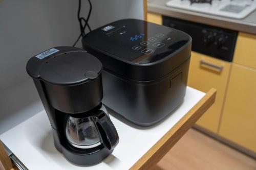 a coffee maker sitting on a counter in a kitchen at Lambrusco in Kami-furano