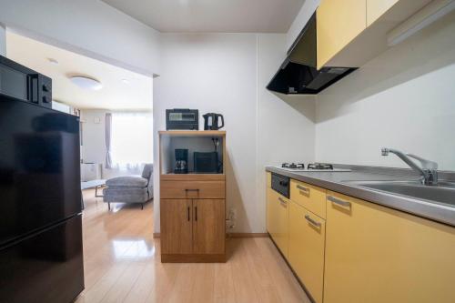 a kitchen with a sink and a refrigerator at Lambrusco in Kami-furano