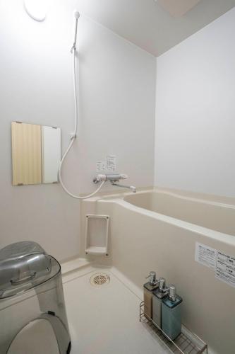 a white bathroom with a toilet and a sink at Lambrusco in Kami-furano