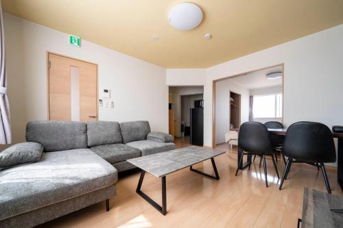 a living room with a couch and a table and chairs at Lambrusco in Kami-furano