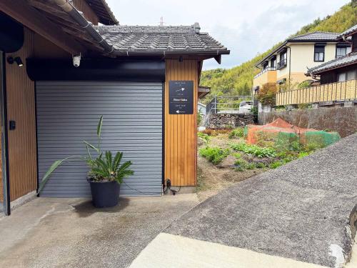 a garage door on a house with a plant at Rino-Haku 01 in Anan