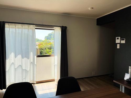 a room with a large window and two chairs at Rino-Haku 01 in Anan