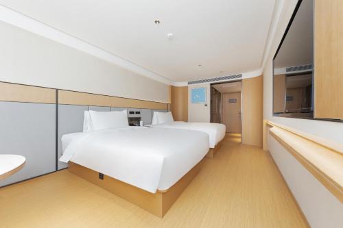 a hotel room with two beds and a kitchen at Beijing JI Hotel Zhongguancun Xueyuan South Road in Beijing