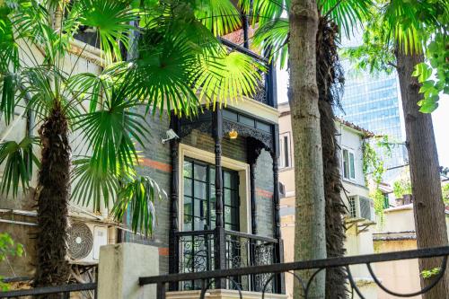 a house with palm trees in front of it at A detached, old Shanghai villa on Huaihai Middle Road in Shanghai