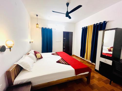 a bedroom with a bed with a mirror and blue curtains at Marari Anandu Beach Villa in Mararikulam