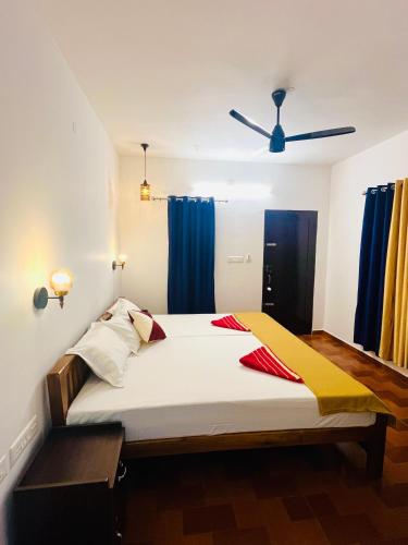 a bedroom with a large bed with blue curtains at Marari Anandu Beach Villa in Mararikulam