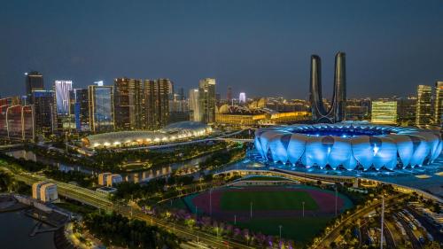a large stadium in a city at night at Crowne Plaza Hangzhou Riverside by IHG in Hangzhou