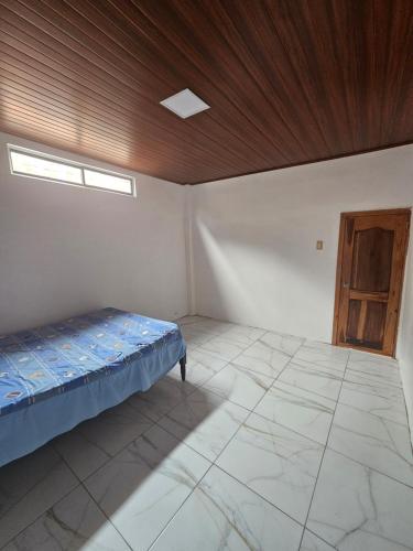 a bedroom with a bed and a wooden ceiling at Casa Moderna en Crucita la Bella in Crucita