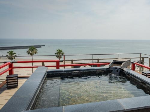 a swimming pool with the ocean in the background at 18歳以上の宿 澄江知多 in Utsumi