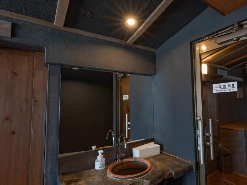 a bathroom with a sink and a mirror at 18歳以上の宿 澄江知多 in Utsumi