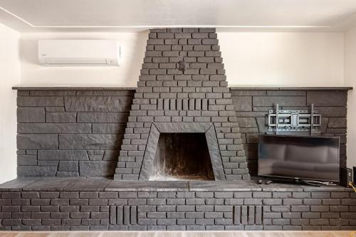 a brick fireplace with a television in it at Cheerful Three Bedroom with a Fireplace in Redding