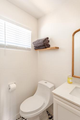 a white bathroom with a toilet and a sink at Cheerful Three Bedroom with a Fireplace in Redding