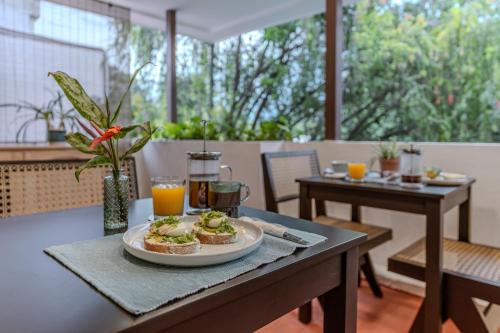 ein Tisch mit einem Teller Essen darauf in der Unterkunft Casa Lúmina - Hotel Boutique y Spa, San Benito in San Salvador