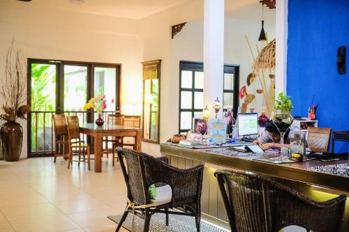 a lobby with a bar with chairs and a table at Tropical Langkawi in Pantai Cenang