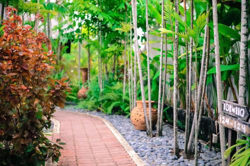 a garden with trees and a brick walkway at Tropical Langkawi in Pantai Cenang