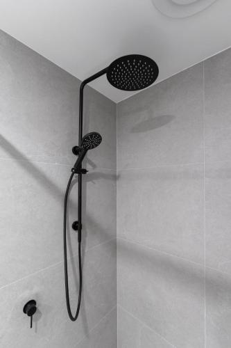 a shower with a shower head in a bathroom at Mangini Apartments - Unit 1 in Perth