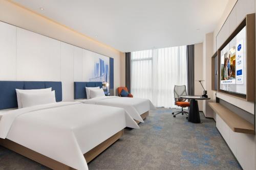 een hotelkamer met twee bedden en een tv bij Hampton by Hilton Hefei Xinqiao International Airport in Hefei