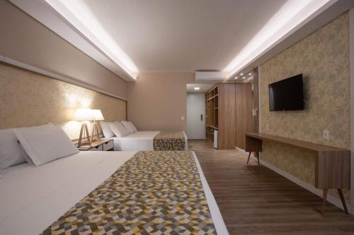 une chambre d'hôtel avec un lit et une télévision dans l'établissement Quarto em Resort de Foz do Iguaçu, à Foz do Iguaçu