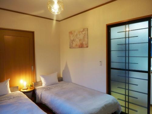 a bedroom with two beds and a window at POLARiS in Tateyama