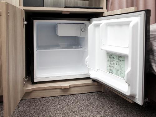 an empty refrigerator with its door open in a kitchen at Hotel Route-Inn Kitamatsudo Ekimae in Matsudo