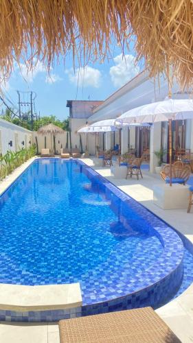 a swimming pool with blue water in a resort at Santai Suites Nusa Dua in Nusa Dua