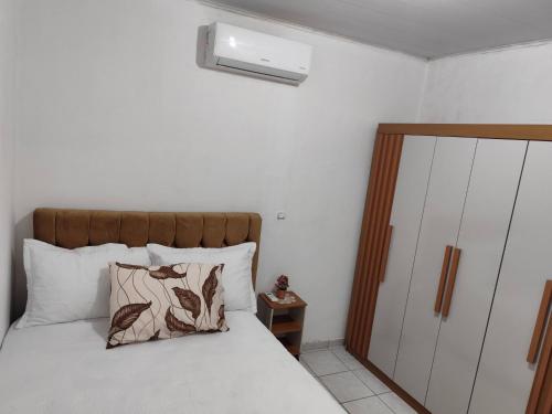 una camera da letto con un letto con testiera in legno di Jb casa temporada a Maceió