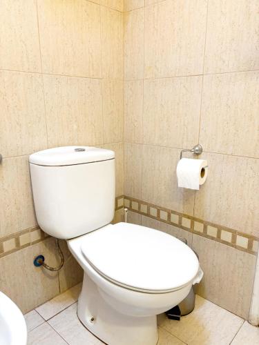 a bathroom with a toilet and a roll of toilet paper at Encantadora y espaciosa casa a dos cuadras de Laguna Chascomús in Chascomús