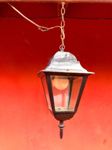 a street light hanging from a red wall at Encantadora y espaciosa casa a dos cuadras de Laguna Chascomús in Chascomús