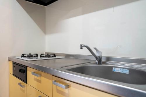 a kitchen with a sink and a stove at Lambent in Kami-furano
