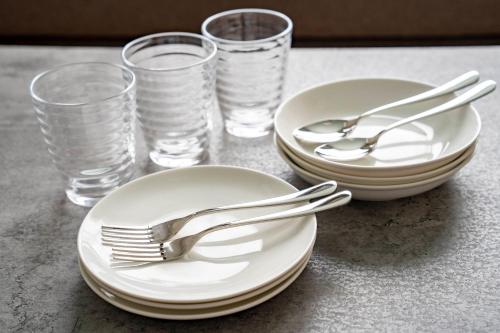 two plates and forks and glasses on a table at Lambent in Kami-furano