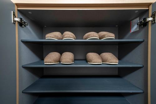a walk in closet with brown shoes on shelves at Lambent in Kami-furano