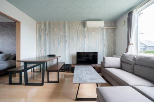 a living room with a couch and a table at Lambent in Kami-furano