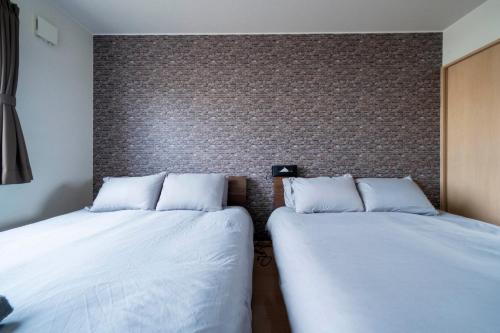 two beds sitting next to each other in a room at Lambent in Kami-furano