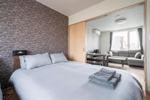 a bedroom with a large bed with towels on it at Lambent in Kami-furano