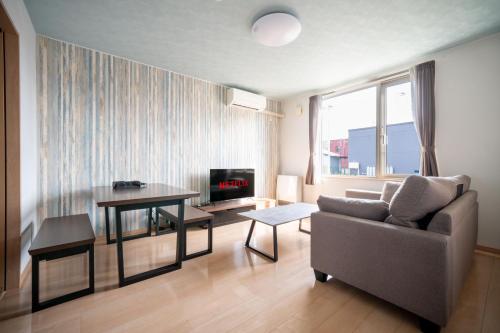 a living room with a couch and a table at Lambent in Kami-furano