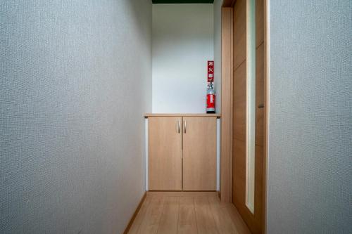 a hallway with a cabinet and a fire hydrant on the wall at Lambent in Kami-furano