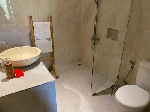 a bathroom with a shower and a sink and a toilet at Oemah Dharma Garden View by EPS in Gianyar