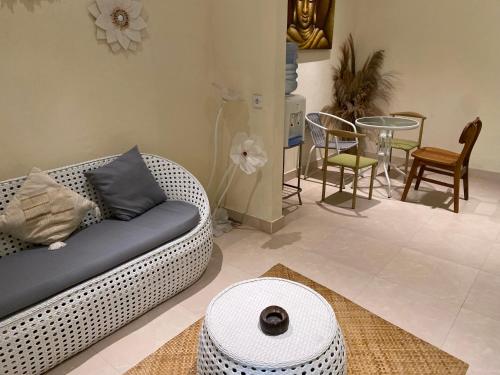 a living room with a couch and a table and chairs at Oemah Dharma Garden View by EPS in Gianyar