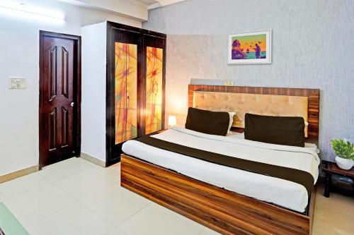 a bedroom with a large bed in a room at Hotel O 9 Palm in Rājpur