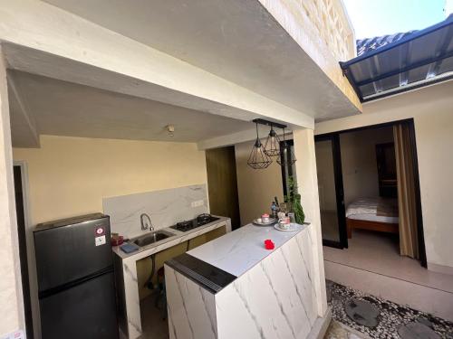 a kitchen with a black refrigerator and a sink at Oemah Dharma Garden View by EPS in Gianyar