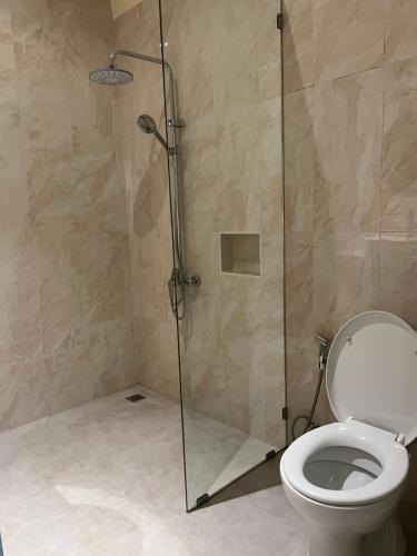 a bathroom with a shower and a toilet at Oemah Dharma Garden View by EPS in Gianyar