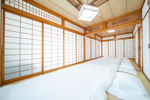 a room with a large bed in a room with windows at O-KiNAWA HOUSE in Onna