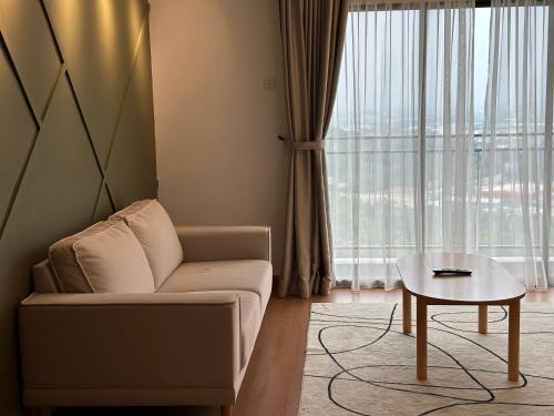 a living room with a couch and a table at Youth City Residences by Manhattan Group in Nilai