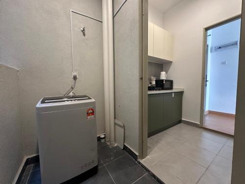 a small kitchen with a small refrigerator in a room at Youth City Residences by Manhattan Group in Nilai