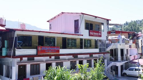 ein weißes Gebäude mit einem Schild an der Seite in der Unterkunft Siddhi Vinayak Residency By StayApart in Gupta Kāshi