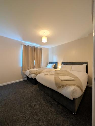 a bedroom with two beds and a window at Numero Uno Comfy 3BR 3 Baths Hot Tub wifi Contractor and Group Friendly in Newcastle upon Tyne